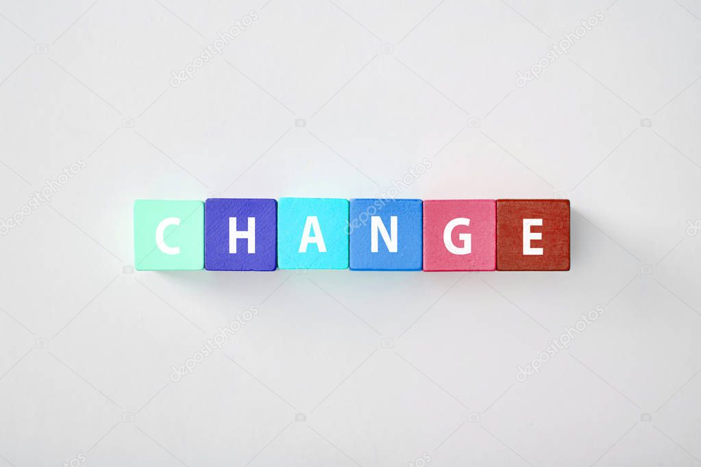 top view of change lettering made of multicolored cubes on grey background