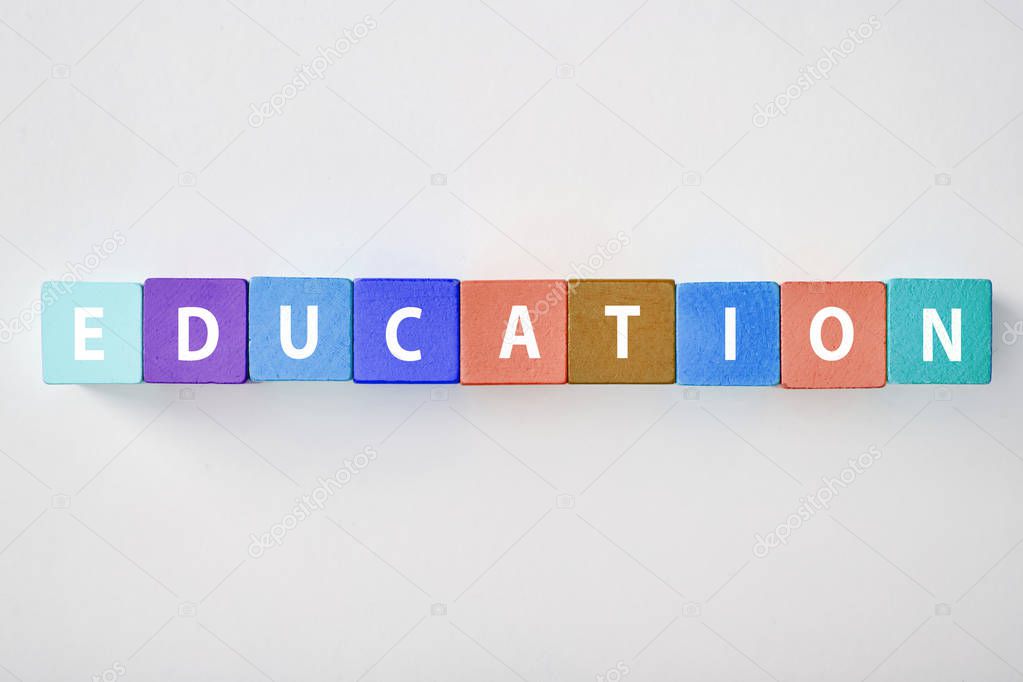 top view of education lettering made of multicolored blocks on grey background