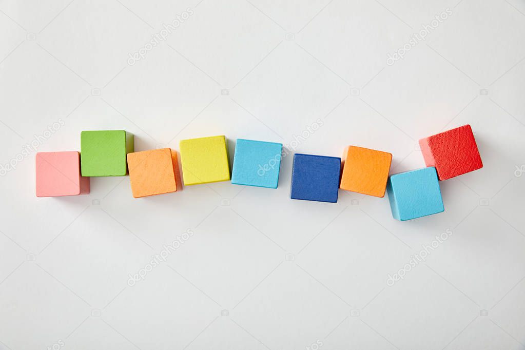 top view of multicolored cubes laid out on grey background