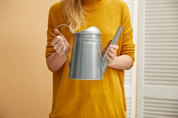 水まき缶を保持している黄色いセーターの女性観をトリミング — ストック写真