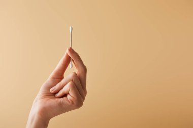 kırpılan görünümünü kulak sopa bej renkli arka plan üzerinde tutan kadın