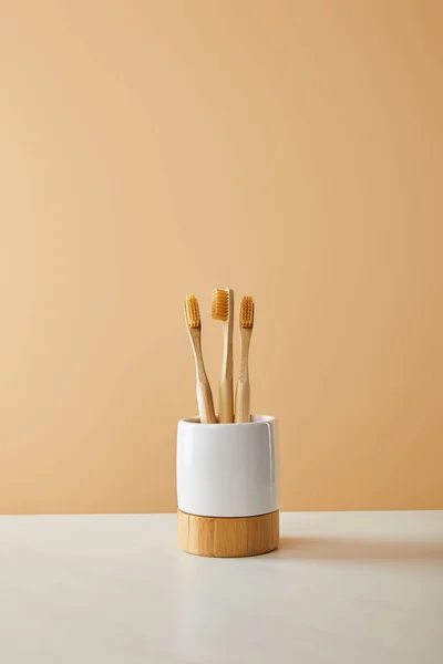 Bambu Diş Fırçası Tutucu Beyaz Masa Bej Renkli Arka Plan — Stok fotoğraf