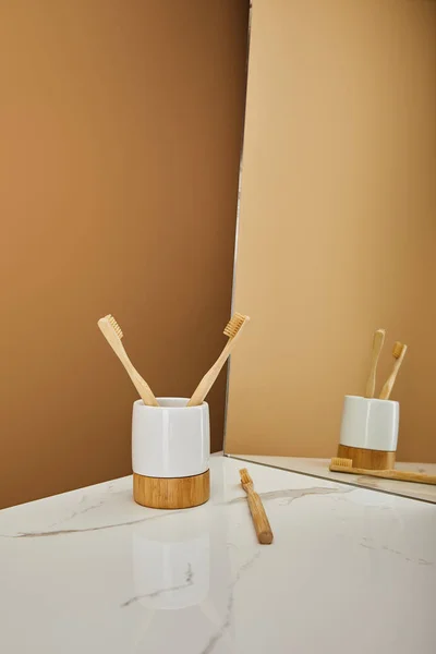 Escovas Dentes Bambu Suporte Espelho Mesa Mármore Branco Fundo Bege — Fotografia de Stock