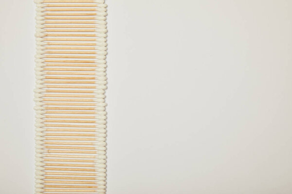 top view of cotton ear sticks laid out vertically on white background