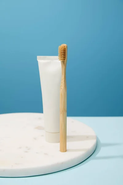 Beyaz Mermer Yuvarlak Tahta Bambu Diş Macunu Tüpü Mavi Arka — Stok fotoğraf