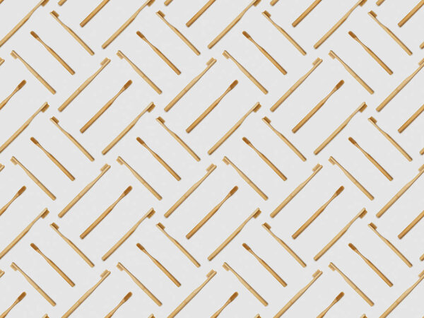 bamboo toothbrushes in different directions on grey background, seamless background pattern