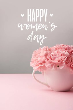 pink carnation flowers in cup on grey background with happy womens day lettering clipart