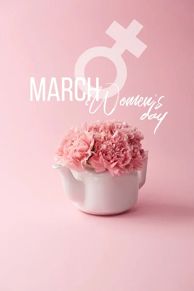 pink carnation flowers in white teapot on pink background with womens day lettering