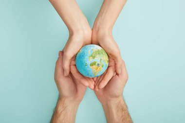 erkek ve kadın gezegen modeli turkuaz arka planda, dünya gün kavramı holding Üstten Görünüm