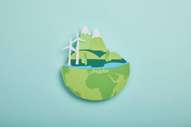 top view of paper cut planet with renewable energy sources on turquoise background, earth day concept clipart