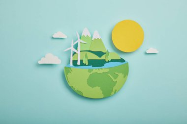 top view of paper cut planet with renewable energy sources on turquoise background, earth day concept clipart