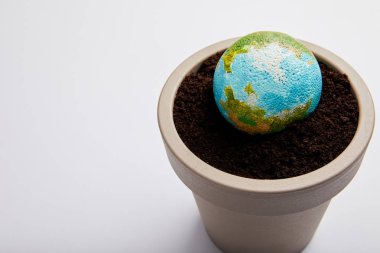 planet model placed on flowerpot with soil, earth day concept clipart