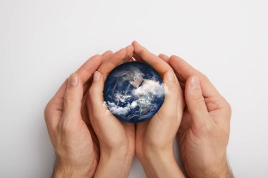 top view of man and woman holding planet model on grey background, earth day concept clipart
