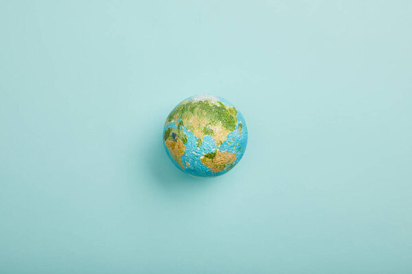 top view of planet model on turquoise background, earth day concept