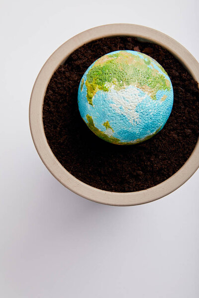 top view of planet model placed on flowerpot with soil, earth day concept
