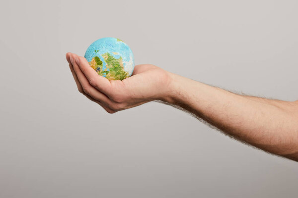 man holding planet model on grey background, earth day concept