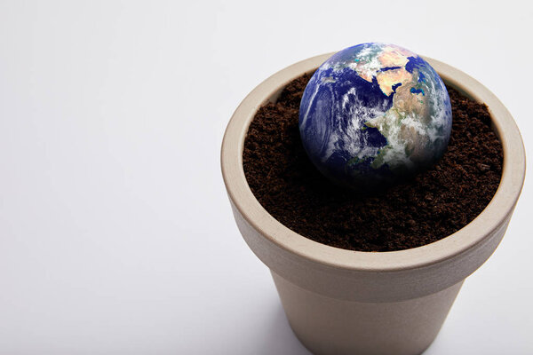 planet model placed on flowerpot with soil, earth day concept