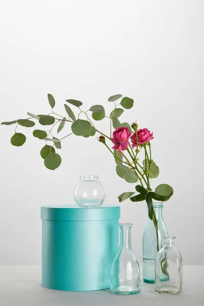 Verse Roze Rozen Eucalyptus Doorzichtige Fles Met Turquoise Geschenkdoos Geïsoleerd — Stockfoto