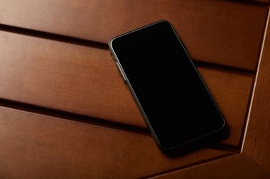 ahşap masa üstünde boş ekran ve kopya yer ile Smartphone