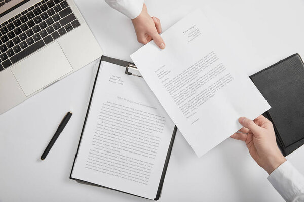 top view of office workers holding document at workspace 