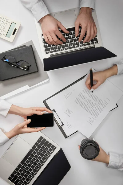 Vista Superior Los Empresarios Escribiendo Ordenador Portátil Sosteniendo Teléfono Inteligente —  Fotos de Stock