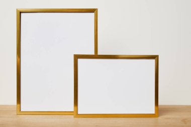 blank frames on wooden table at home clipart
