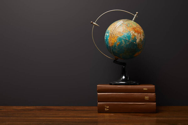 globe near books on wooden textured table