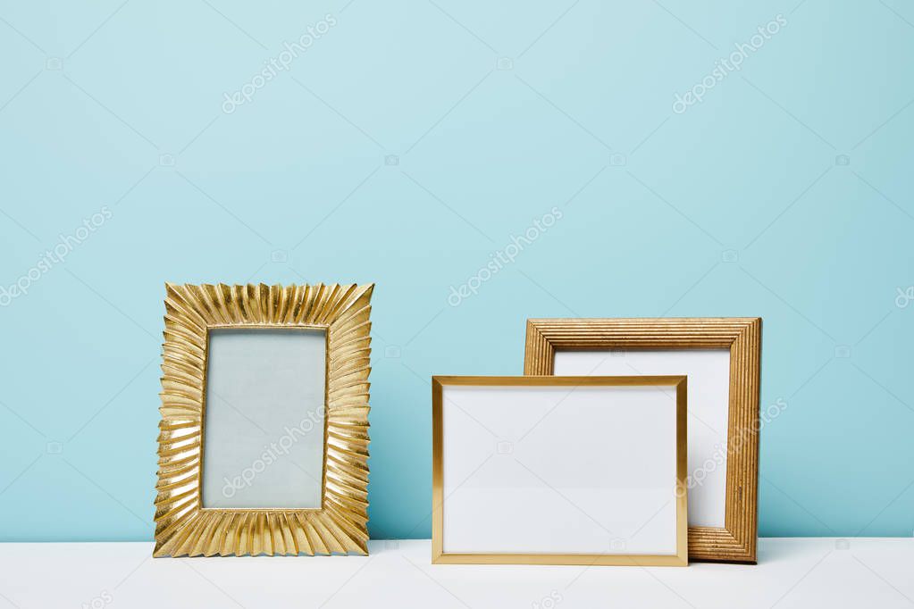 blank decorative frames near blue wall 