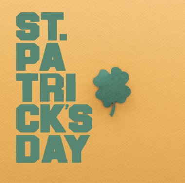 yeşil kağıt shamrock yakınındaki st patrick günü yazı turuncu zemin üzerine