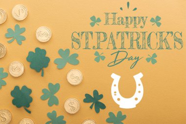 top view of golden coins with dollar signs near shamrocks and happy st patricks day lettering on orange background clipart