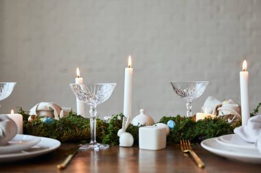 Kristal gözlük, evde peçete ve dishware masaya yanan mumlar, yeşil yosun ve bıldırcın yumurtası