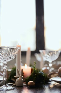 seçici odak ahşap masa evde mum ve kristal gözlük yakınındaki dekoratif tavşan