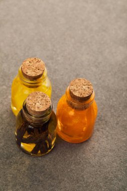 Top view of glass bottles with organic essential oil on dark surface clipart