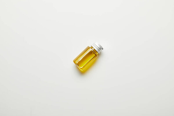 Top view of bottle with essential oil on white background