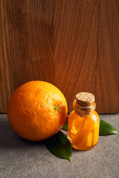 Naranja Entera Con Botella Vidrio Aceite Esencial Superficie Oscura — Foto de Stock