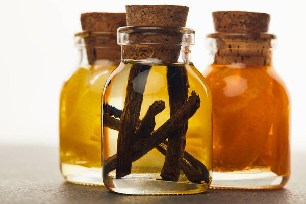 Close up view of glass bottles with organic essential oil on white background