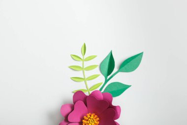 top view of pink paper flower and green plants on grey background clipart