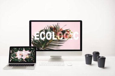 bilgisayar üstünde okul sırası perde ile kağıt bardak beyaz zemin üzerine Eko yazı ile laptop monitör ve ekolojik yazı ile