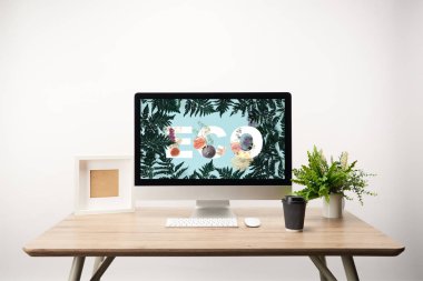 yeşil yaprakları ve ahşap masa üzerinde monitörde Eko yazı ile bilgisayar