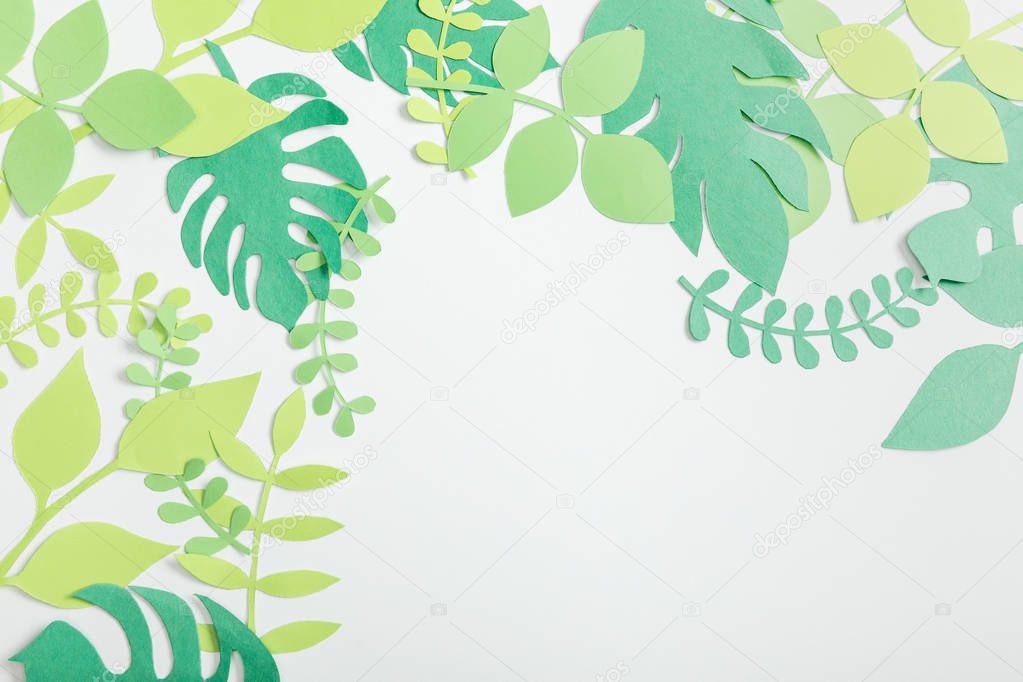 top view of green paper plants with leaves on grey background