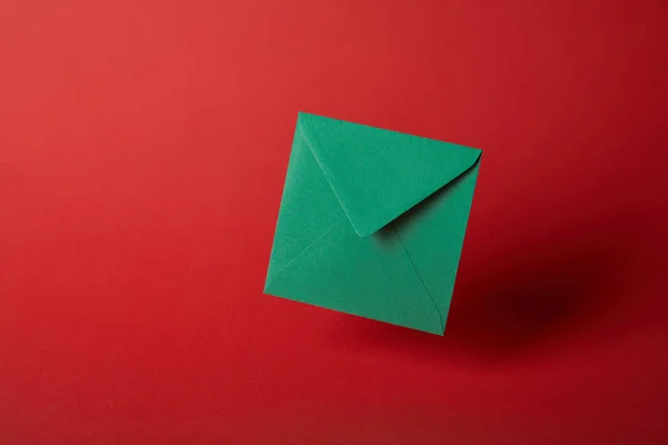 Envelope Brilhante Colorido Verde Fundo Vermelho Com Espaço Cópia — Fotografia de Stock