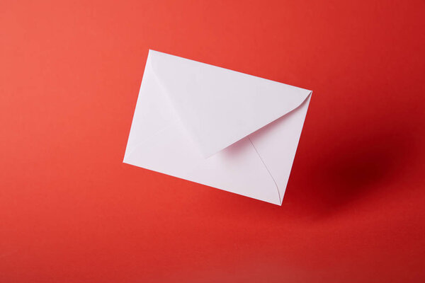 белый и пустой конверт на красном ярком фоне с копированием пространства
 
