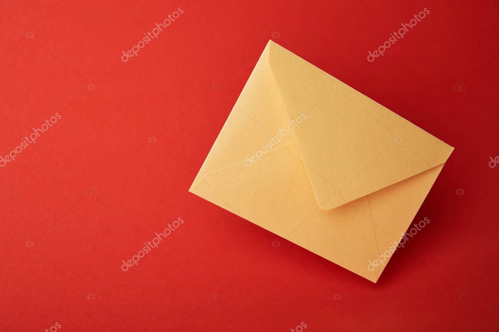 Bright, colorful and yellow envelope on red background with copy space