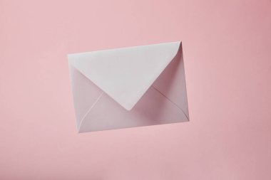 white and empty envelope isolated on pink with copy space clipart