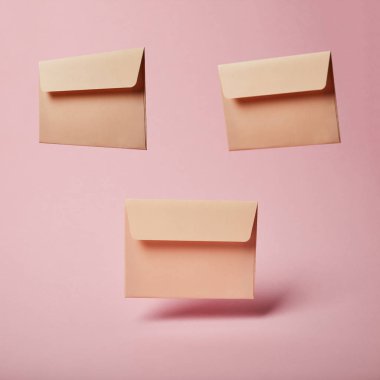 pembe ve pastel arka plan üzerinde kopya alanı ile bej zarflar 