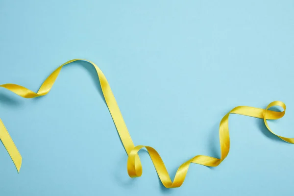 Вид Сверху Желтую Атласную Ленту Голубом Фоне — стоковое фото
