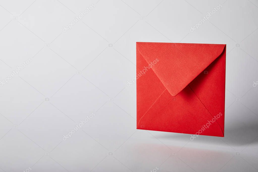 Red and bright envelope on grey background with copy space
