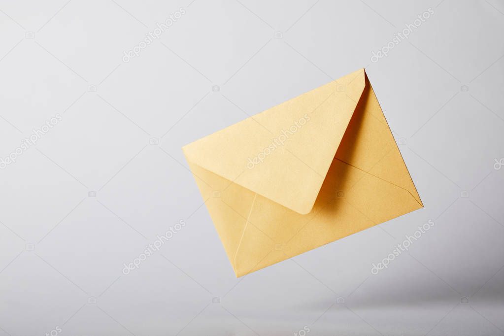 Yellow and bright envelope on grey background with copy space