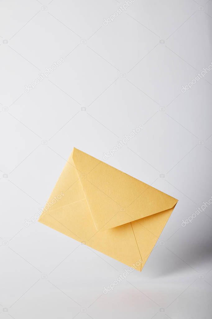 Yellow and bright envelope on grey background with copy space