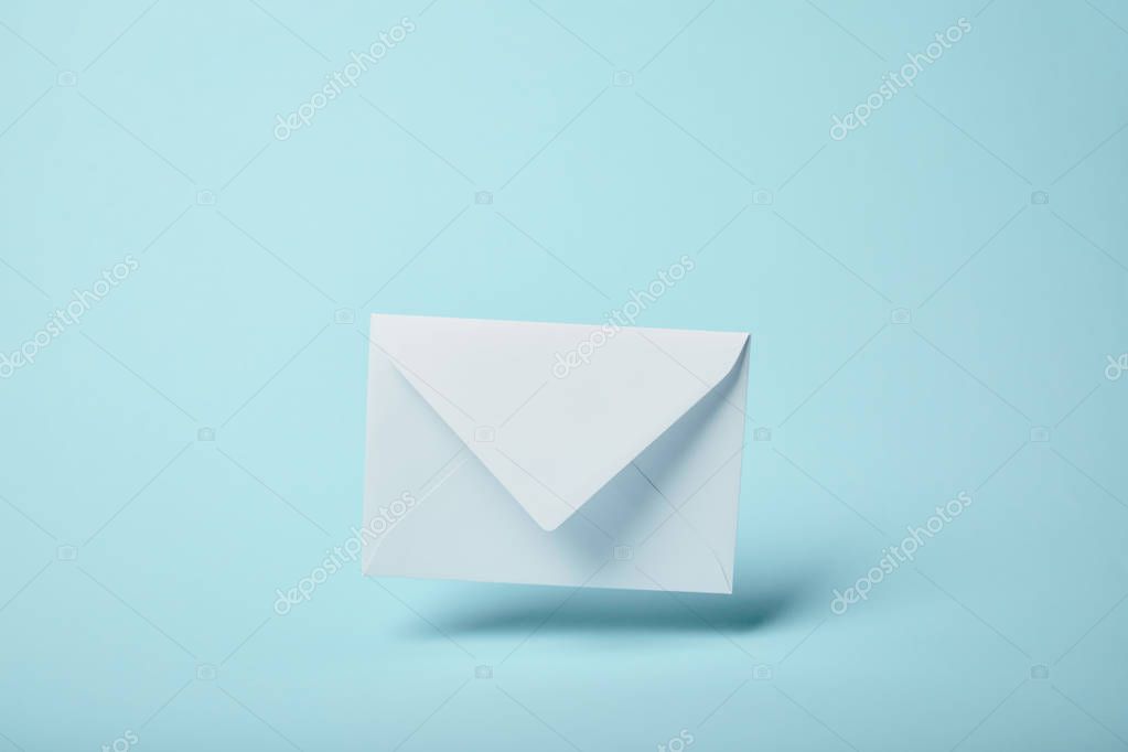 White and blank envelope on blue background with copy space